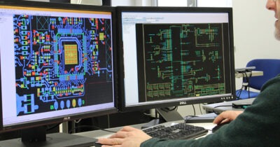 An engineer designs a PCB layout on a computer